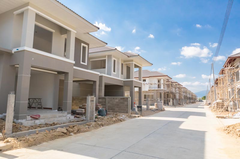 New residential homes under construction, sunny day.